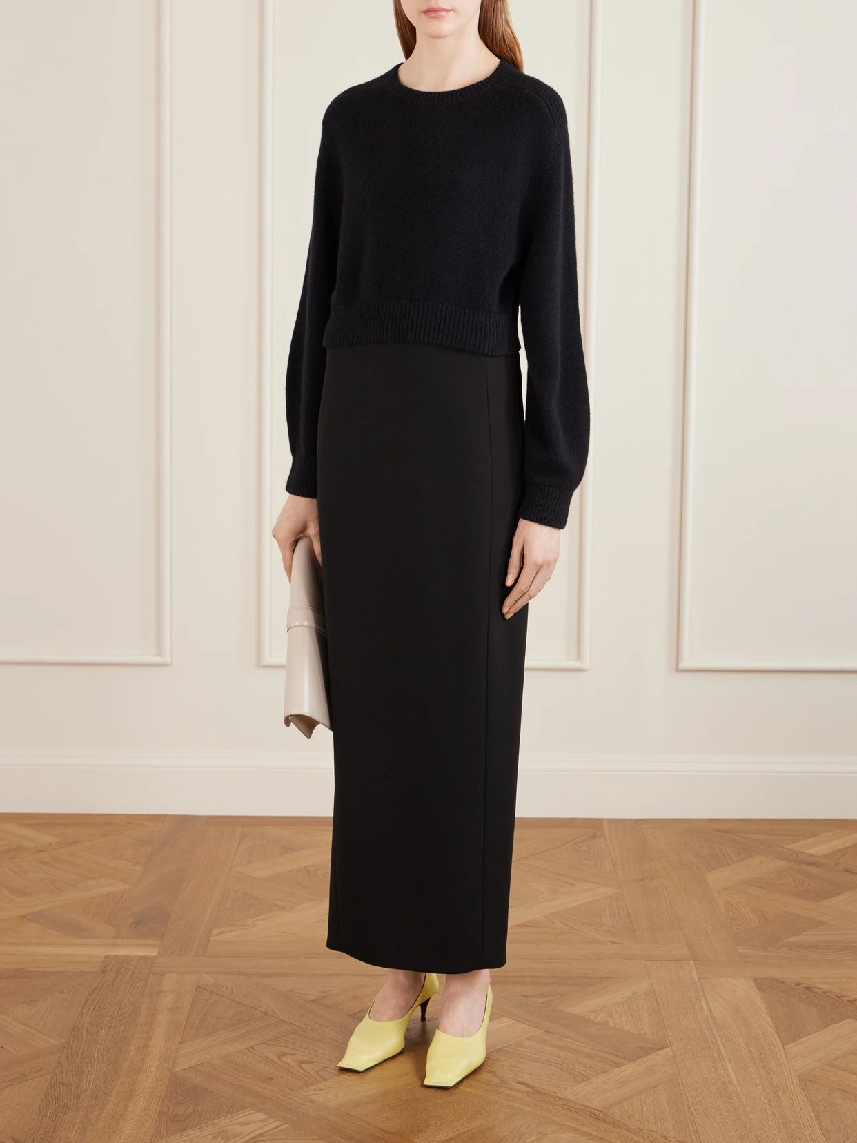 Image of a model wearing Skirts. Product name - Lyle Crepe Midi Skirt in Black colour by brand - KHAITE