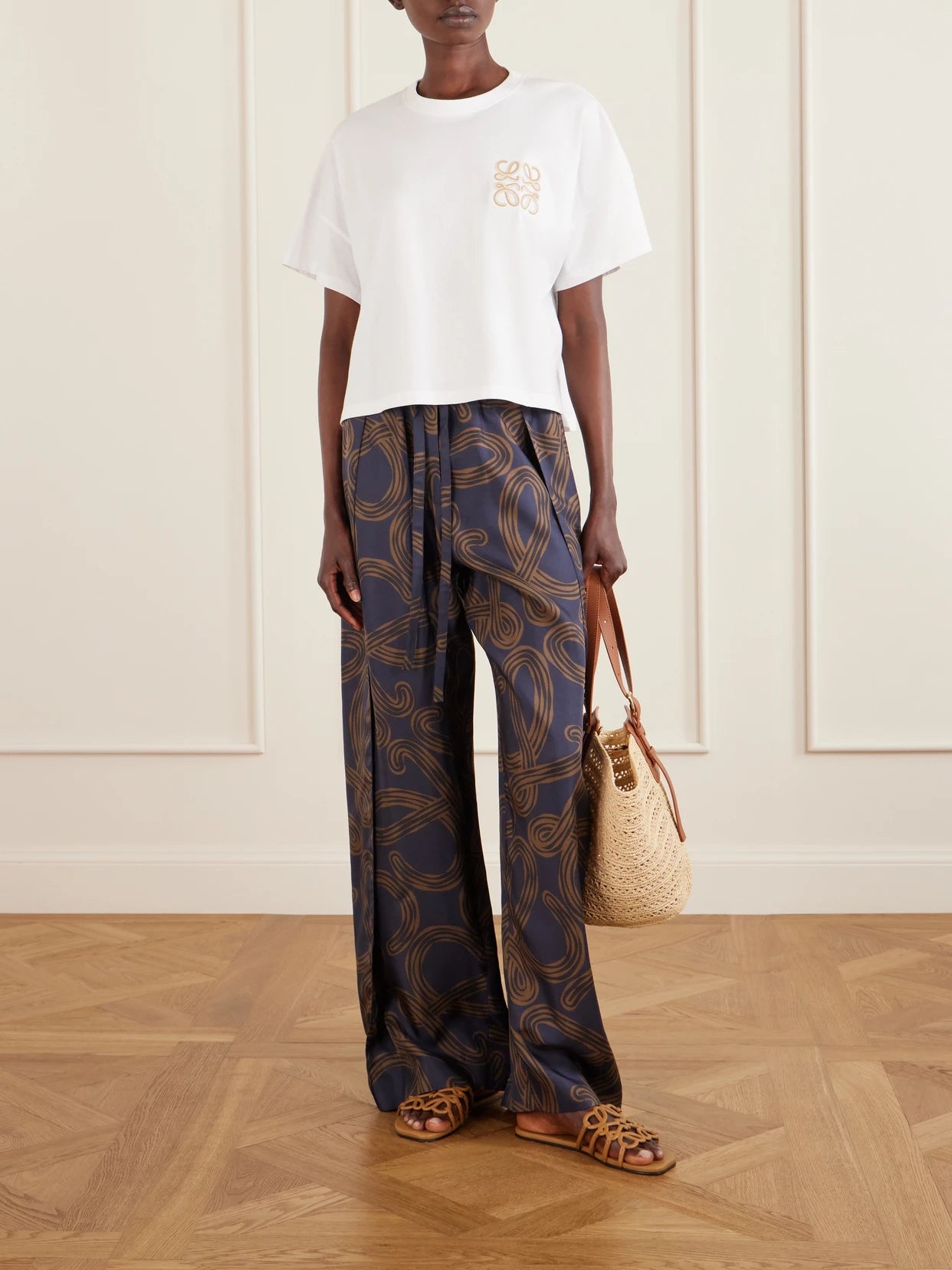 Image of a model wearing Tops. Product name - + Paula's Ibiza Logo-embroidered Cotton-jersey T-shirt in White colour by brand - LOEWE