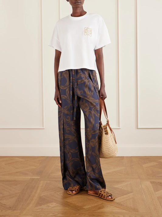 Image of a model wearing Tops. Product name - + Paula's Ibiza Logo-embroidered Cotton-jersey T-shirt in White colour by brand - LOEWE