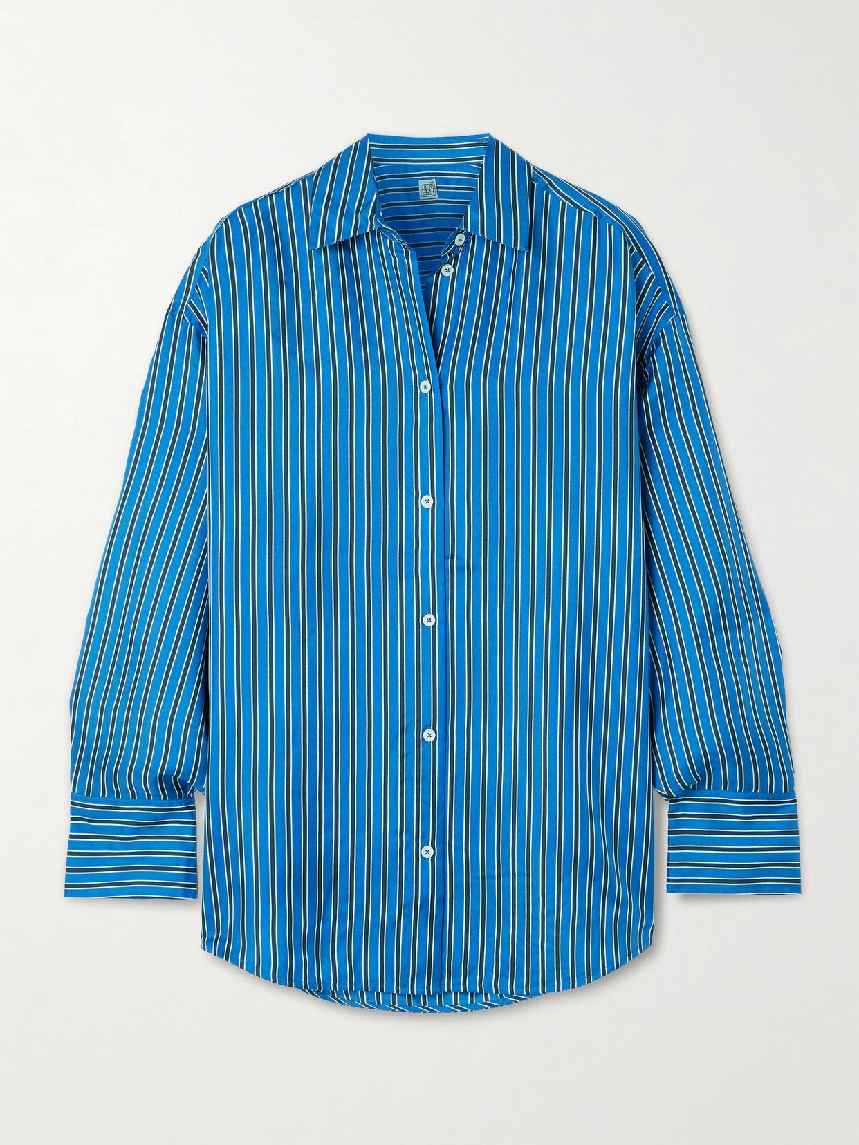 Image of a model wearing Tops. Product name - Oversized Striped Silk-twill Shirt in Blue colour by brand - TOTEME