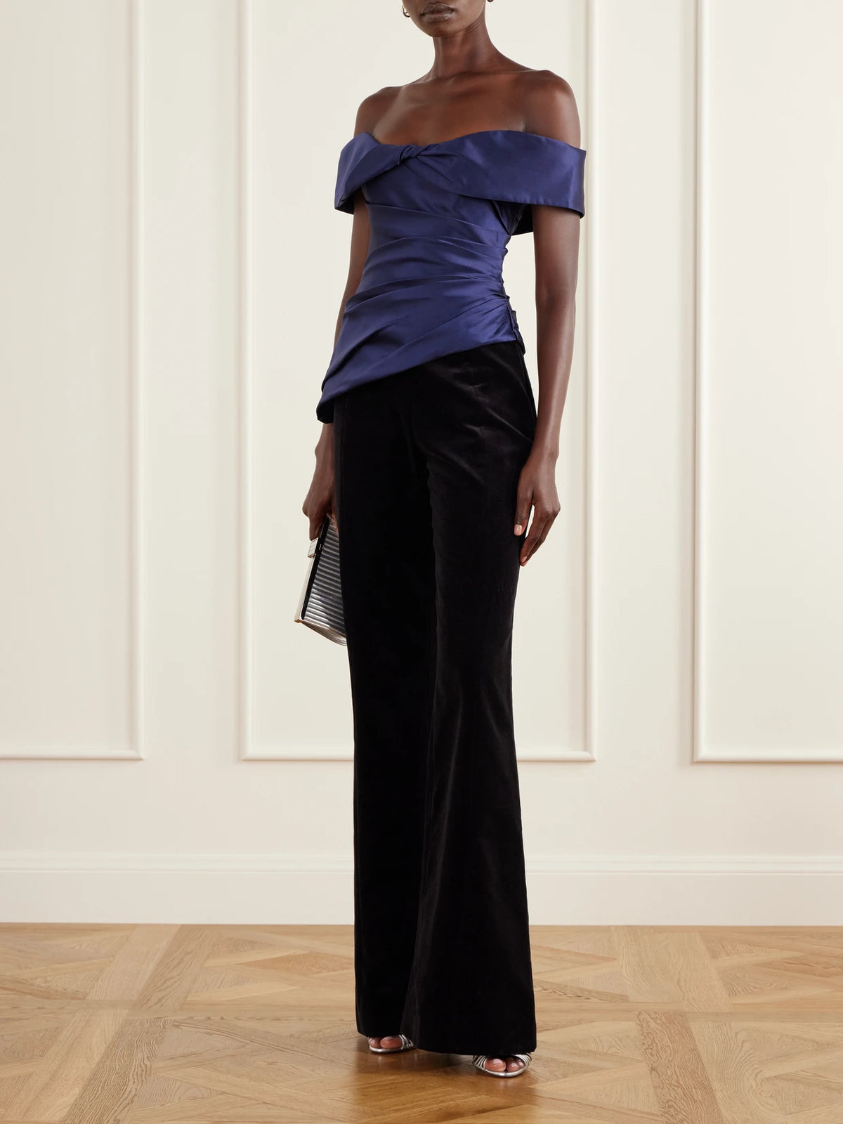 Image of a model wearing Tops. Product name - Devina Off-the-shoulder Draped Duchess-satin Blouse in Navy colour by brand - Costarellos