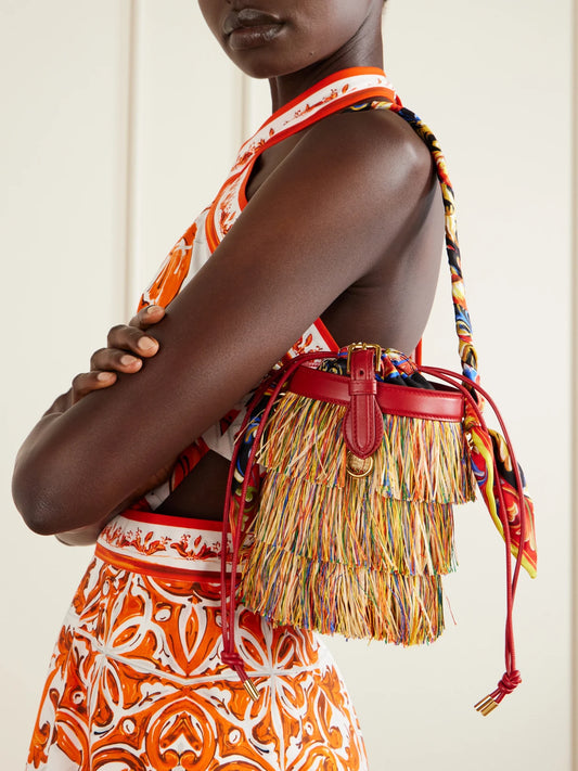 Image of Bags. Product name - Capri Fringed Leather And Twill-trimmed Raffia Bucket Bag in Multi colour by brand - Dolce & Gabbana