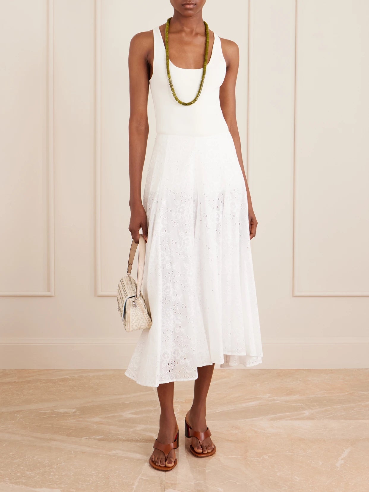 Image of a model wearing Skirts. Product name - Pleated Broderie Anglaise Cotton Midi Skirt in White colour by brand - Tory Burch
