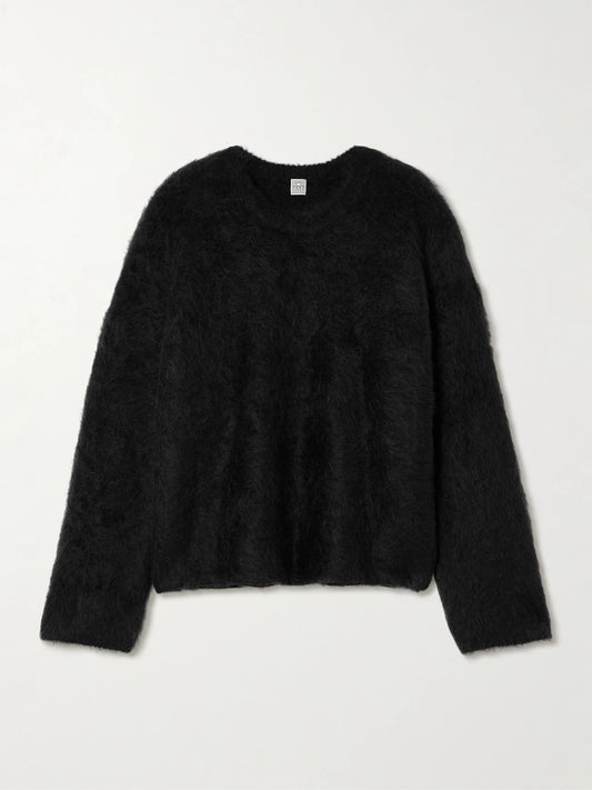 Image of a model wearing Outerwear. Product name - Oversized Ribbed Alpaca-blend Sweater in Black colour by brand - TOTEME