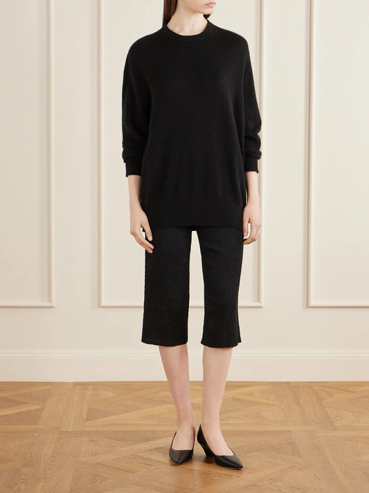 Image of a model wearing Outerwear. Product name - Odelle Cashmere Knit Sweater in Black colour by brand - The Row