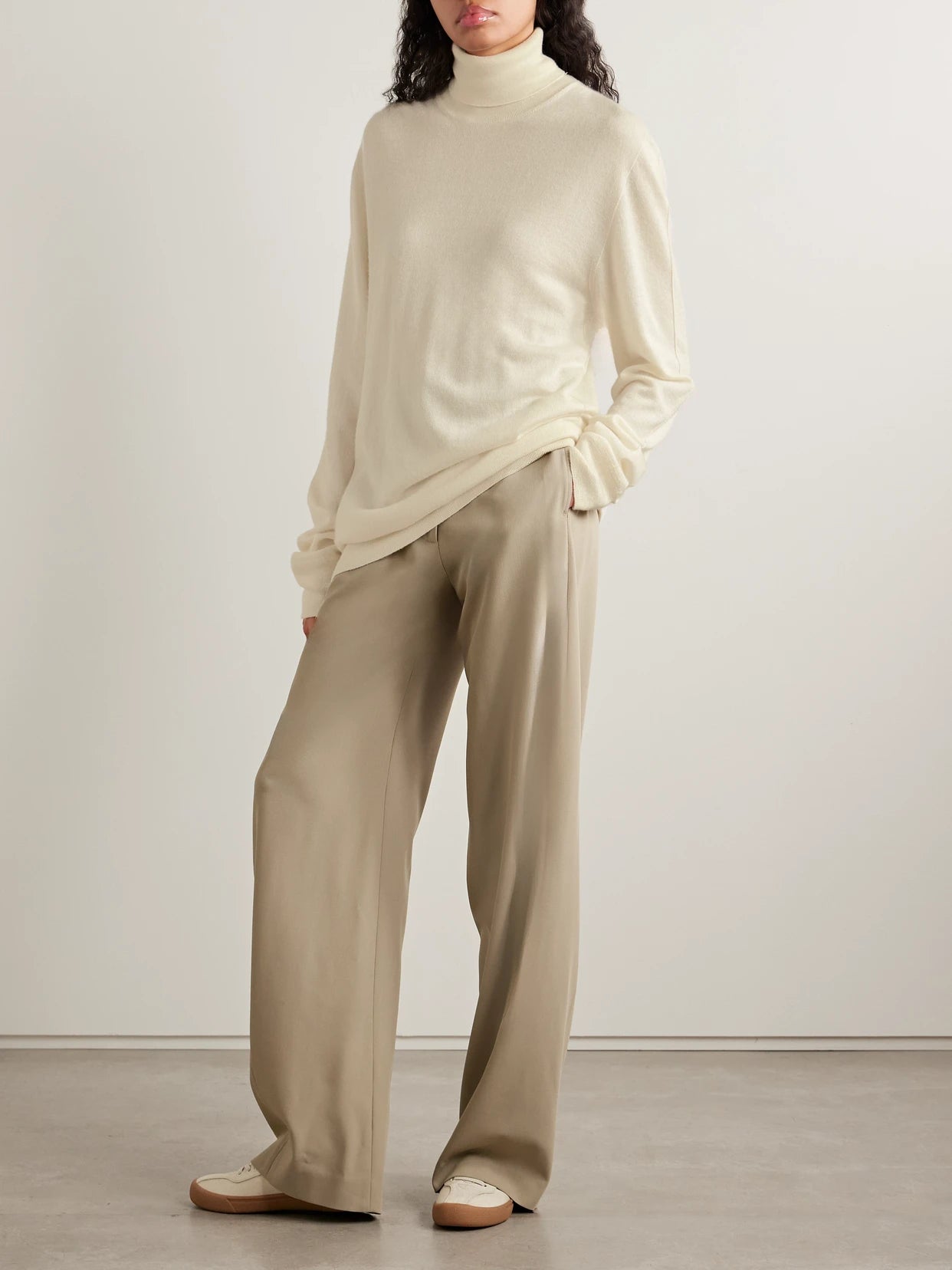 Image of a model wearing Outerwear. Product name - Lizzy Oversized Cashmere Turtleneck Sweater in Ivory colour by brand - The Row