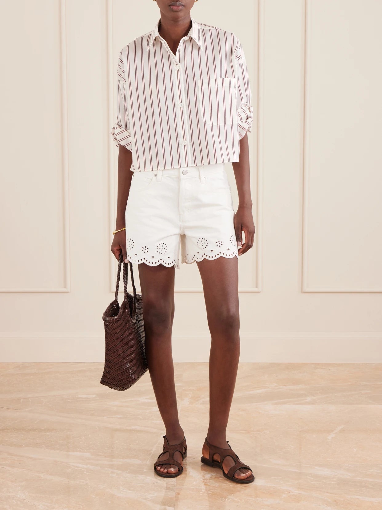 Image of a model wearing Shorts. Product name - Broderie Anglaise-trimmed Denim Shorts in White colour by brand - FRAME
