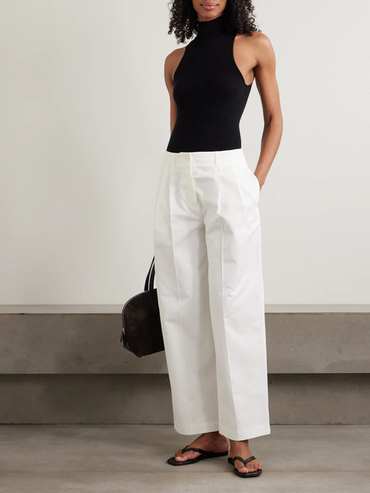 Image of a model wearing Pants. Product name - Pleated Cotton-twill Wide-leg Pants in White colour by brand - TOTEME