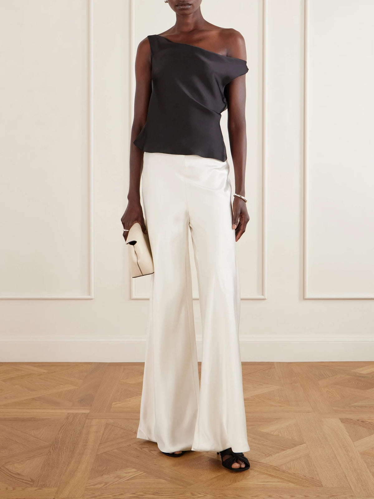 Image of a model wearing Tops. Product name - Maria Satin One-shoulder Top in Black colour by brand - Norma Kamali