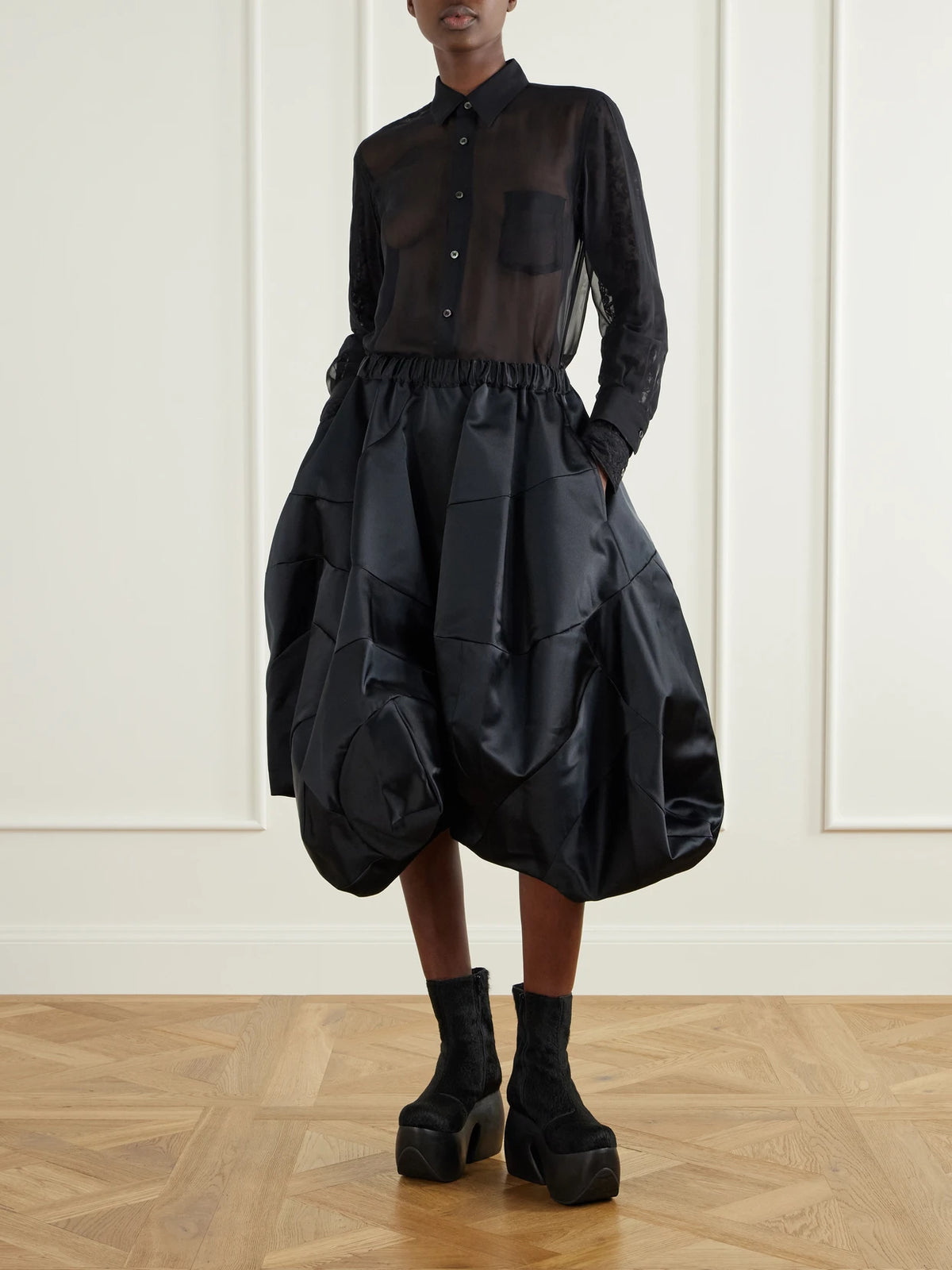 Image of a model wearing Skirts. Product name - Gathered Satin Midi Skirt in Black colour by brand - Comme des Garçons