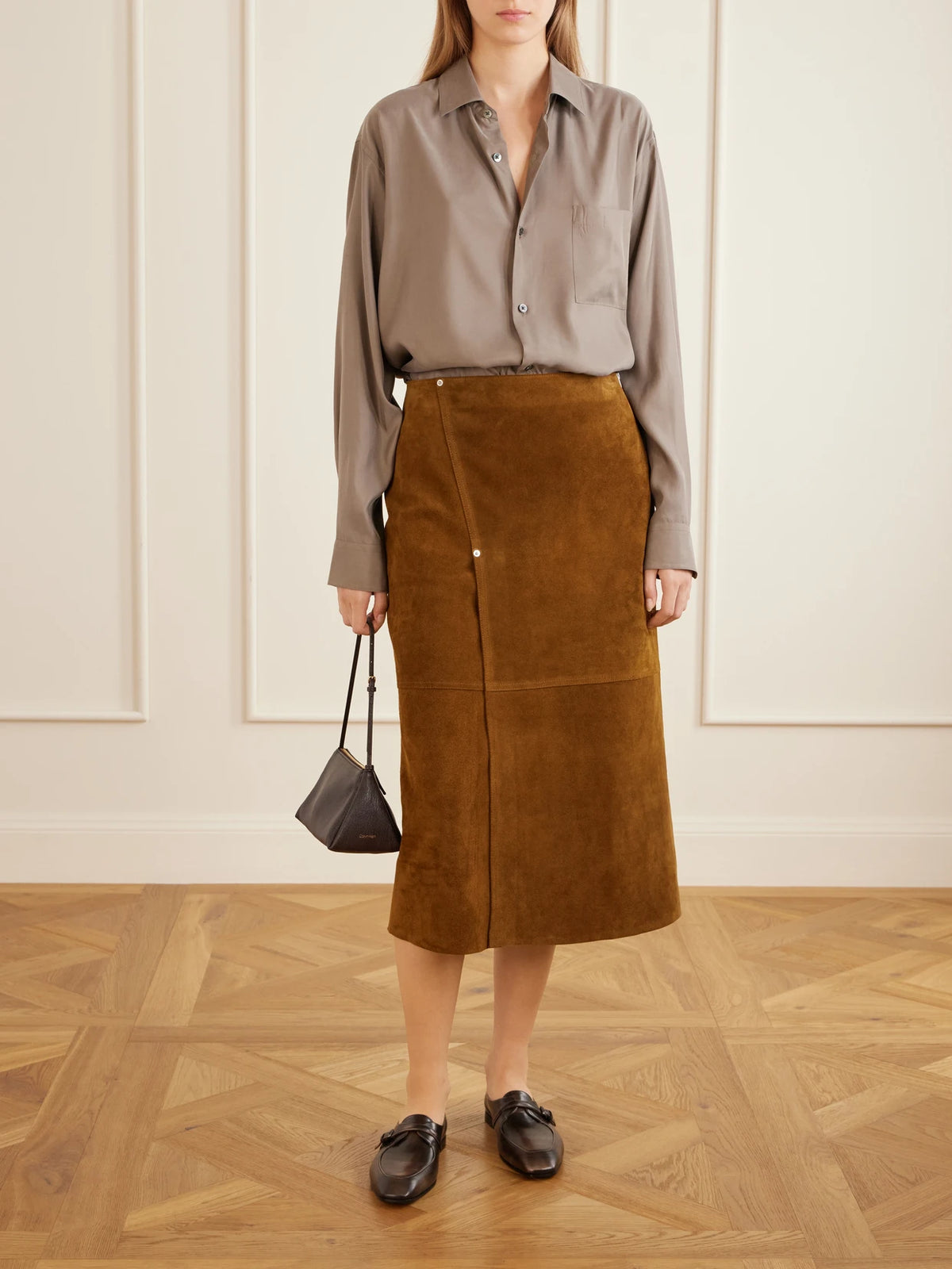 Image of a model wearing Skirts. Product name - Melete Suede Midi Skirt in Mustard colour by brand - Studio Nicholson