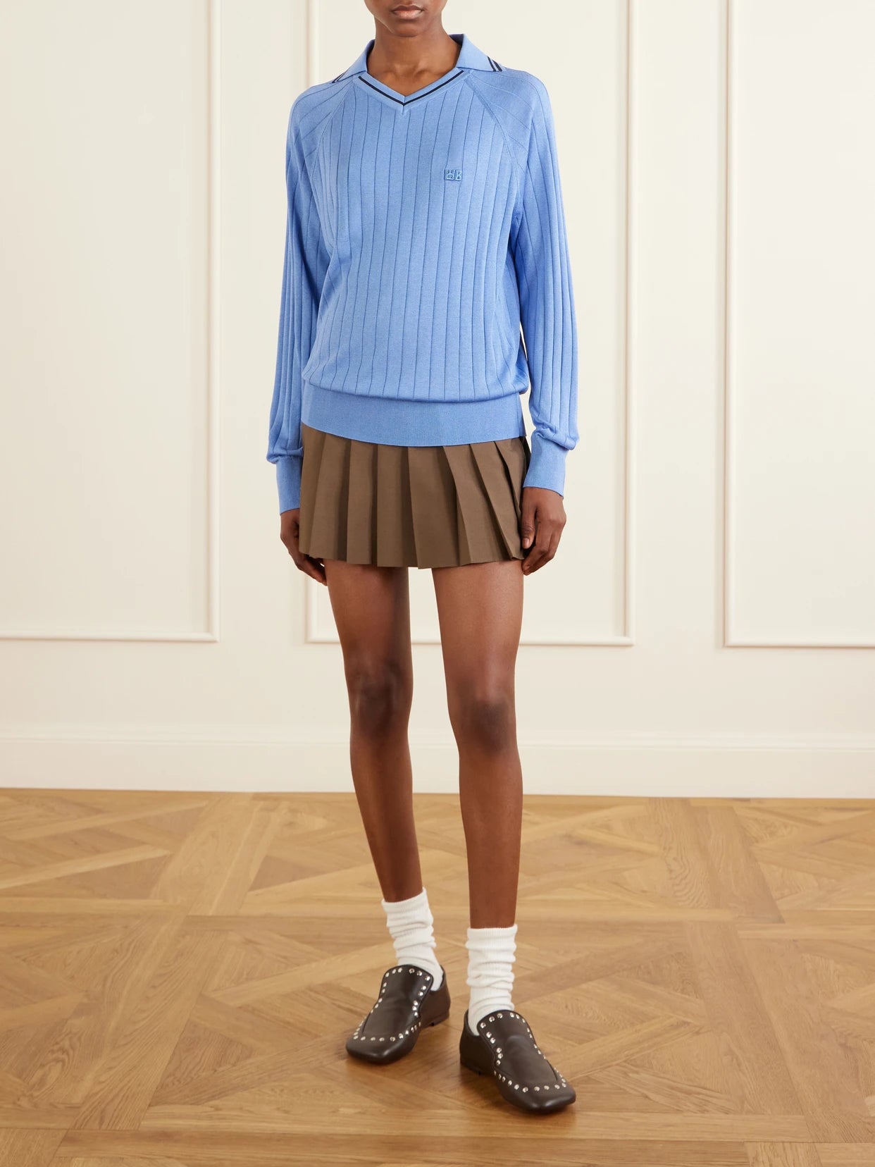 Image of a model wearing Outerwear. Product name - Roots Logo-embroidered Striped Polo Shirt in Blue colour by brand - Wales Bonner