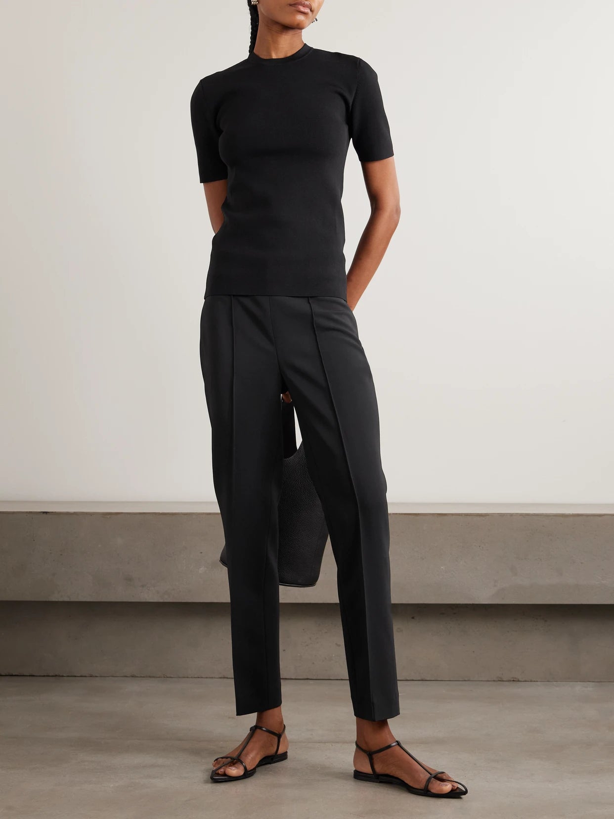Image of a model wearing Pants. Product name - Pintucked Grain De Poudre Skinny Pants in Black colour by brand - RÓHE