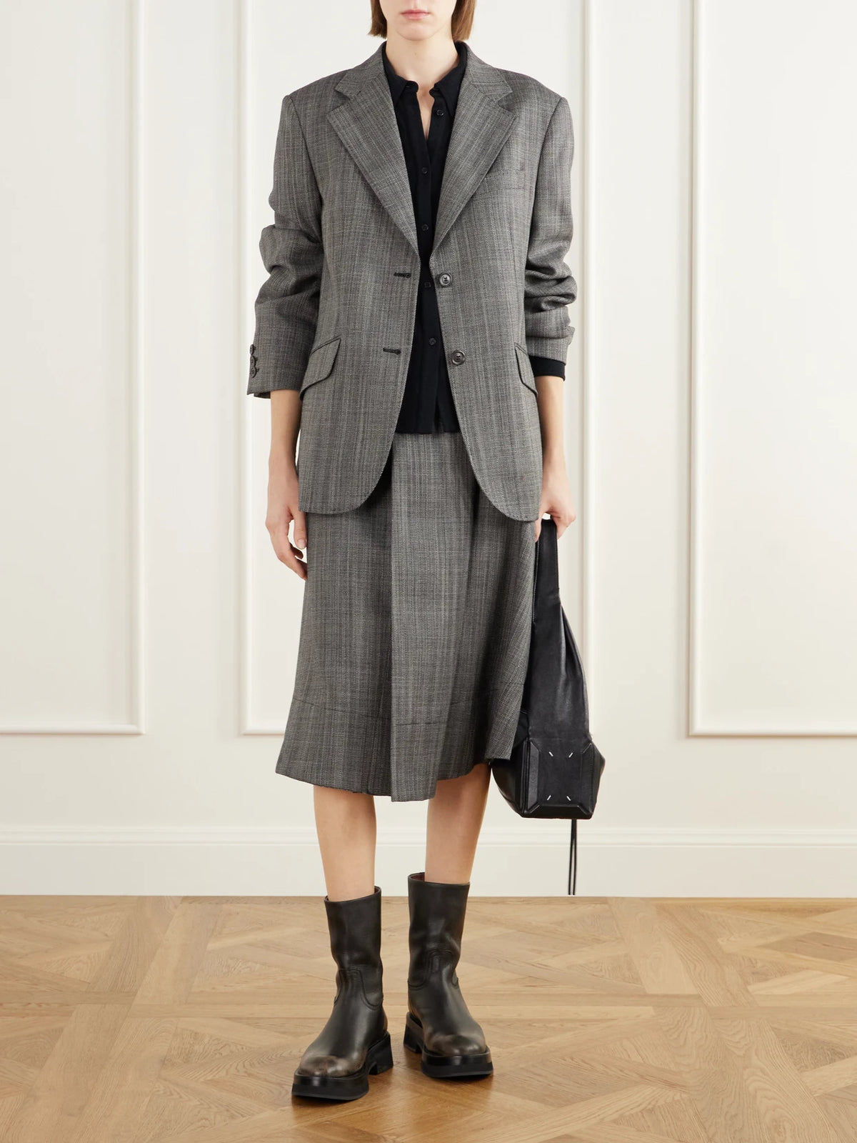 Image of a model wearing Skirts. Product name - Mono Wool Broken Twill Wrap Midi Skirt in Gray colour by brand - Our Legacy
