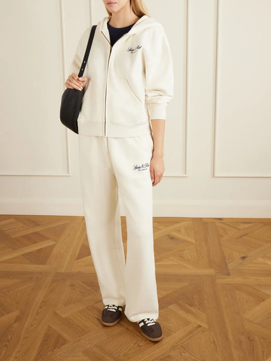 Image of Sleepwear & Loungewear. Product name - Vendome La Embroidered Cotton-fleece Track Pants in Ecru colour by brand - Sporty & Rich