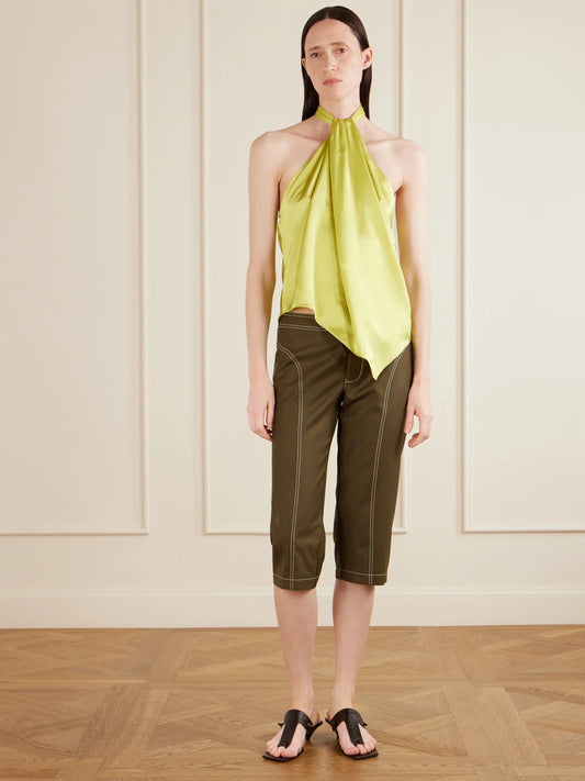 Image of a model wearing Pants. Product name - Zuri Wool-twill Slim-fit Capri Pants in Bright green, Black colour by brand - AFLALO