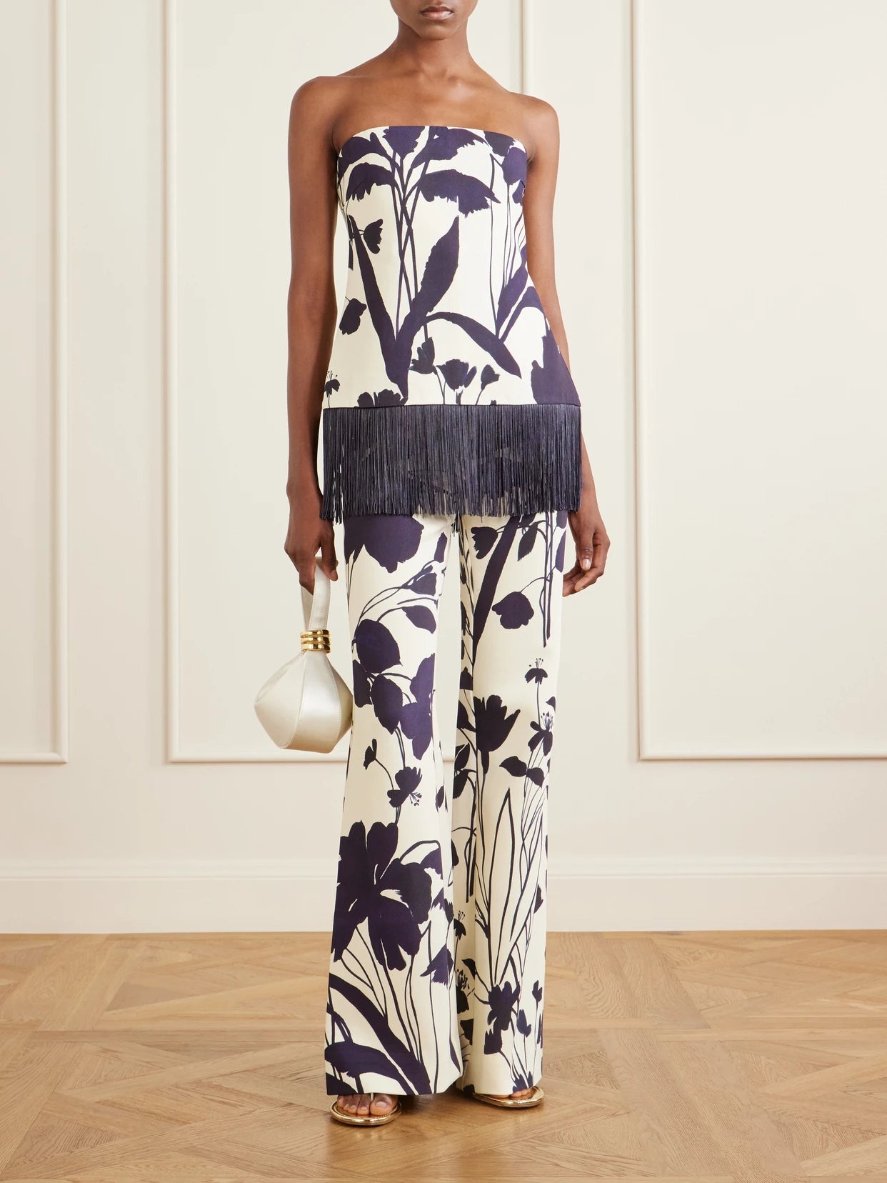 Image of a model wearing Pants. Product name - Pisa Floral-print Stretch-crepe Wide-leg Pants in Ivory colour by brand - Cara Cara