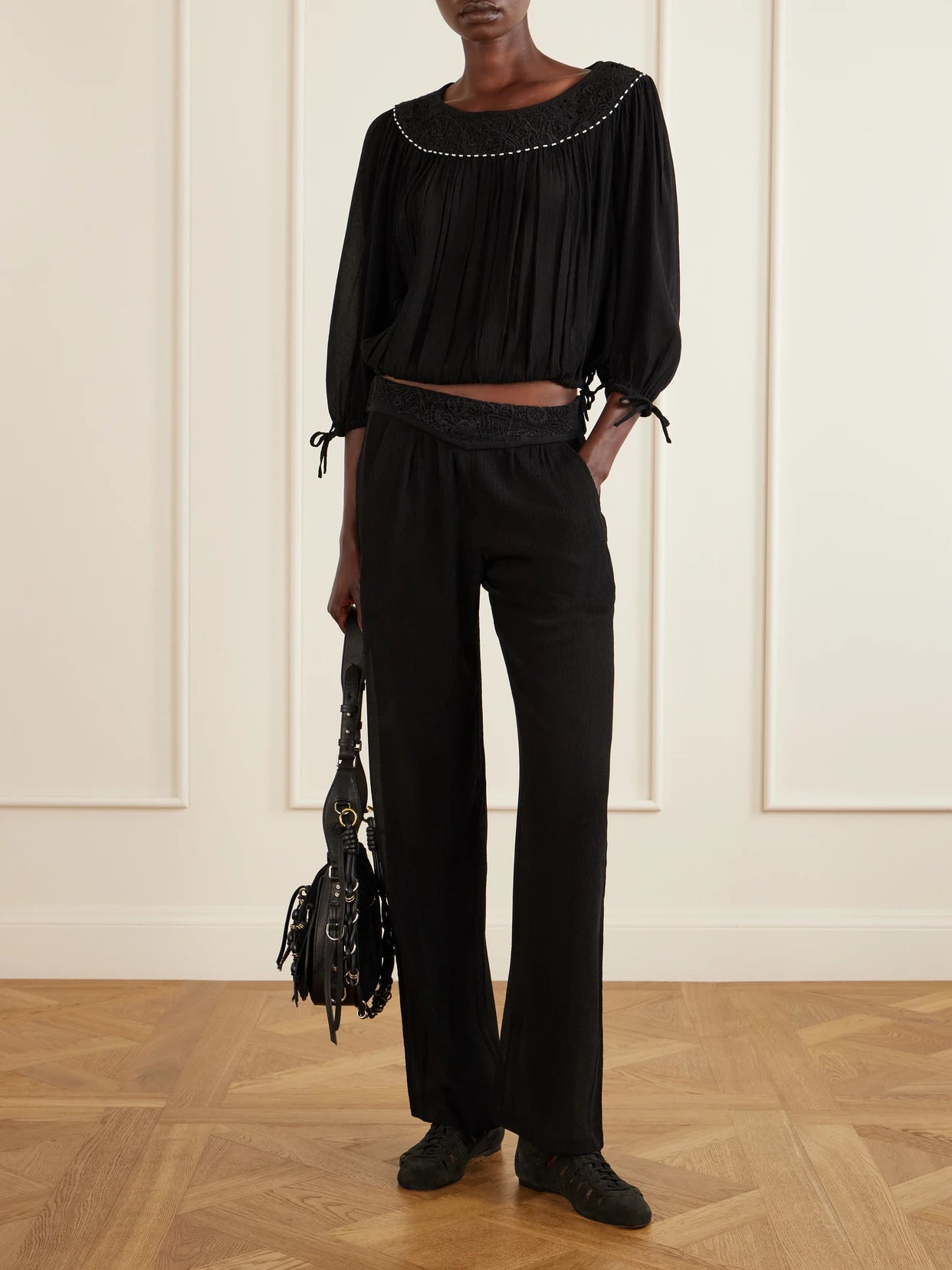 Image of a model wearing Pants. Product name - Guylene Lace-trimmed Silk-crepe Straight-leg Pants in Black colour by brand - ISABEL MARANT