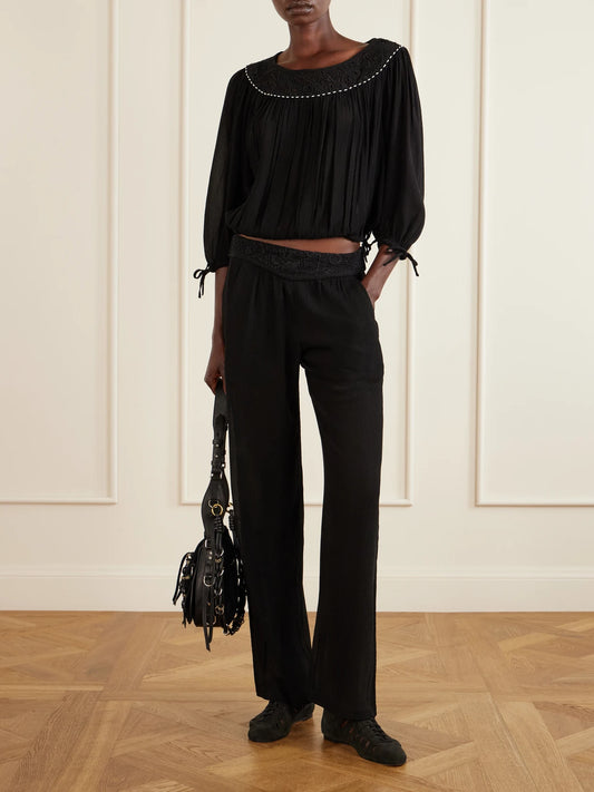 Image of a model wearing Pants. Product name - Guylene Lace-trimmed Silk-crepe Straight-leg Pants in Black colour by brand - ISABEL MARANT