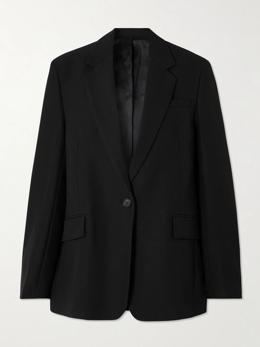 Image of a model wearing Outerwear. Product name - Garderob Oversized Recycled Grain De Poudre Blazer in Black colour by brand - TOTEME