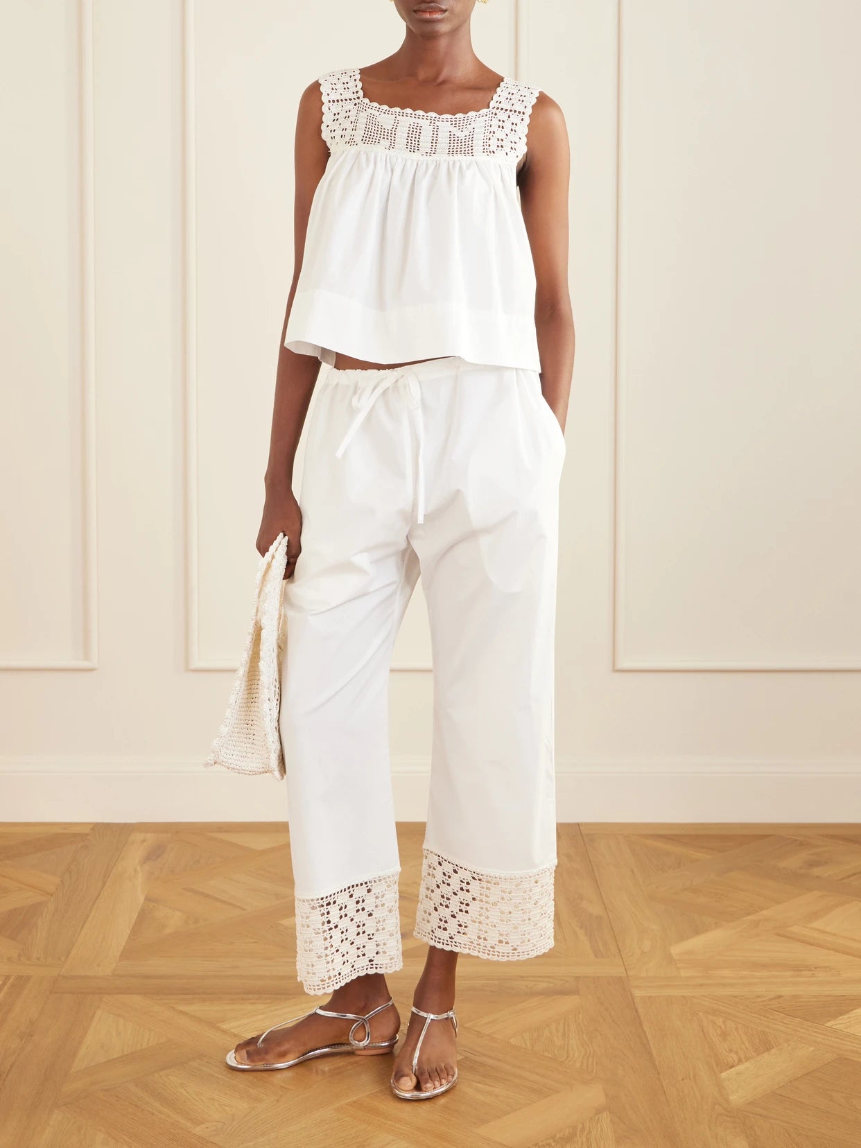 Image of a model wearing Pants. Product name - Heriloom Lace-trimmed Cotton-poplin Wide-leg Pants in White colour by brand - Calle Del Mar