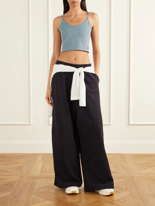 Image of a model wearing Tops. Product name - + Zendaya Paneled Organic Cotton-blend Jersey Wide-leg Sweatpants in Black, Light gray colour by brand - ON