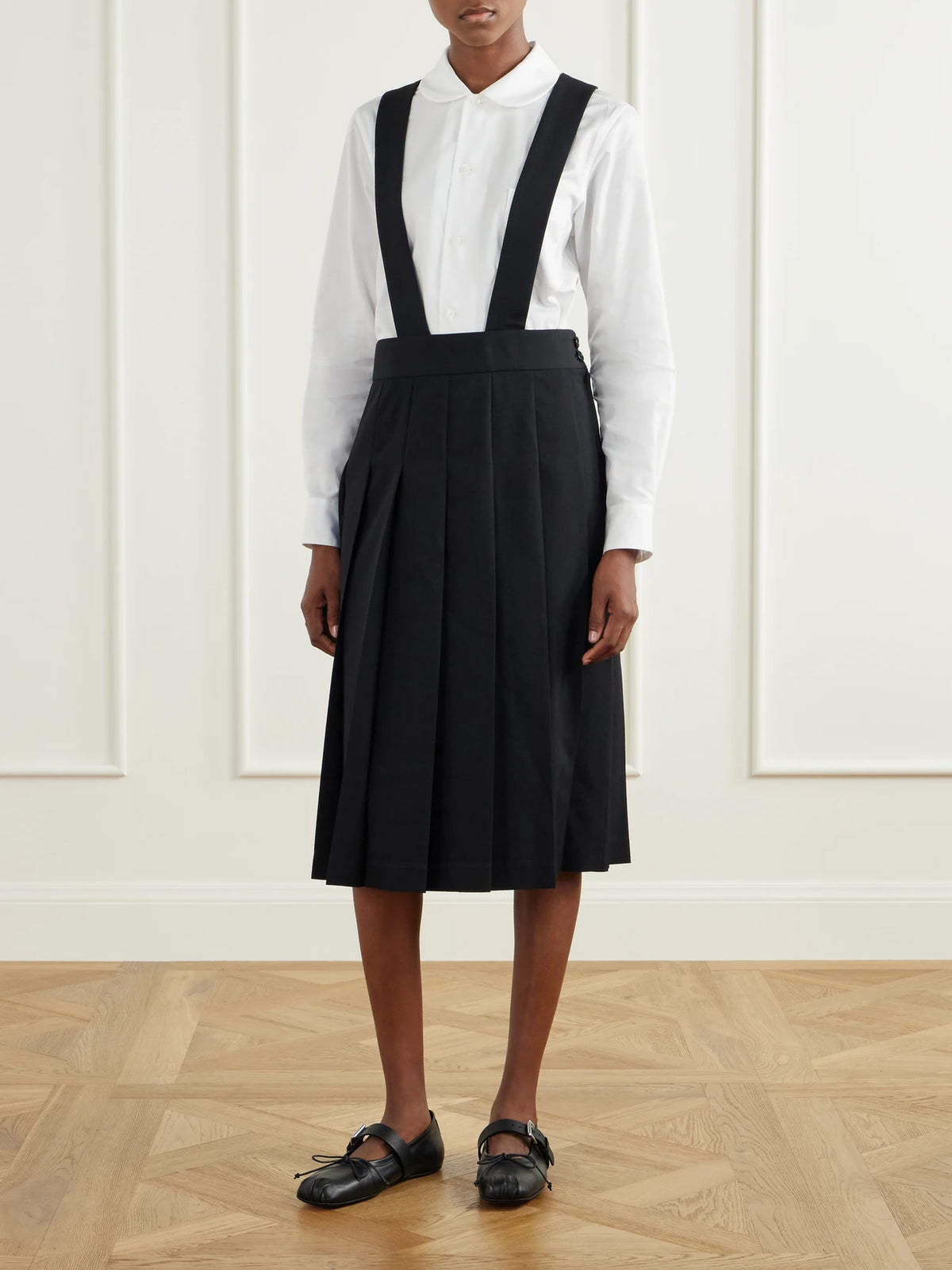 Image of a model wearing Skirts. Product name - Pinafore Wool Midi Skirt in Black colour by brand - Comme des Garçons GIRL