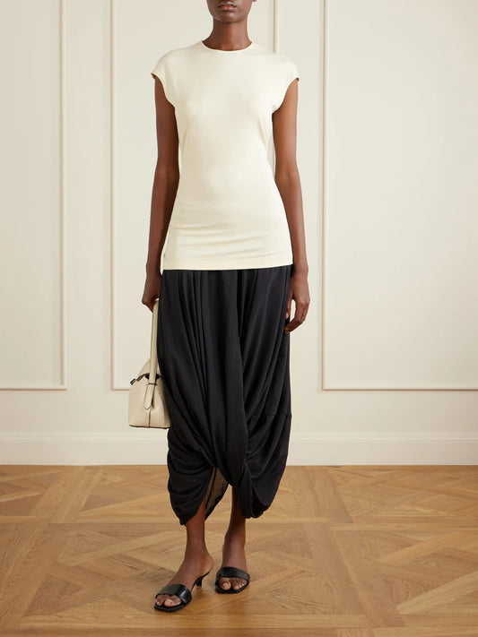 Image of a model wearing Skirts. Product name - Cocoon Draped Lyocell And Organic Cotton-blend Maxi Skirt in Black colour by brand - TOTEME