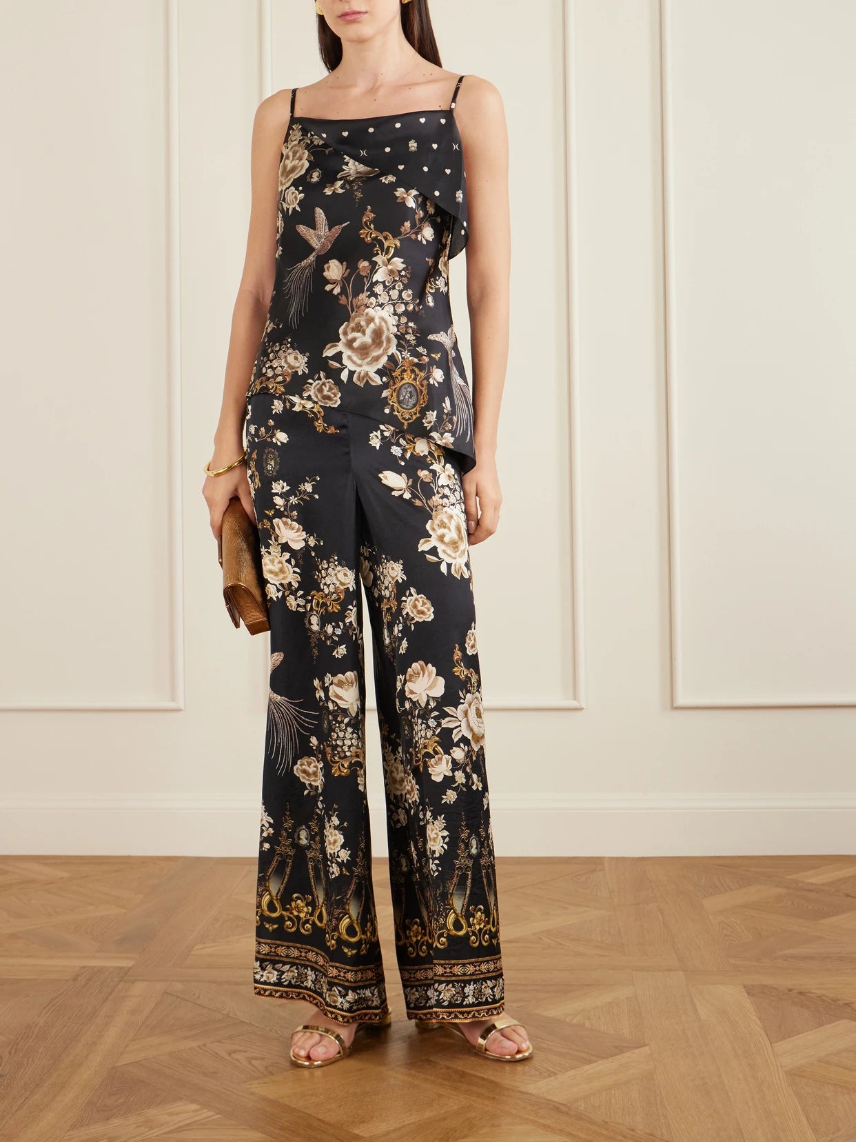 Image of a model wearing Tops. Product name - Asymmetric Draped Embellished Embroidered Printed Silk-satin Top in Black colour by brand - Camilla