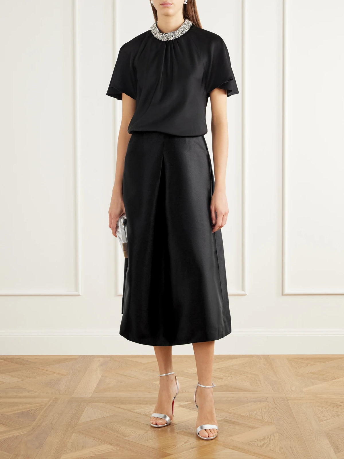 Image of a model wearing Skirts. Product name - Vexa Pleated Duchess-satin Midi Skirt in Black colour by brand - SIMKHAI