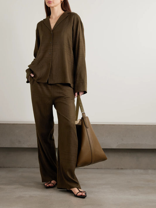Image of a model wearing Pants. Product name - Embroidered Tencel Lenzing Modal Pants in Dark brown colour by brand - TOTEME