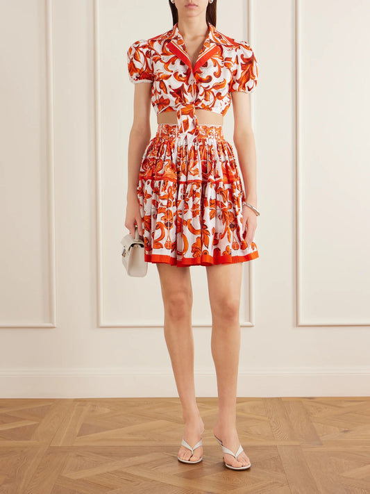 Image of a model wearing Tops. Product name - Cropped Printed Cotton-poplin Top in Orange colour by brand - Dolce & Gabbana