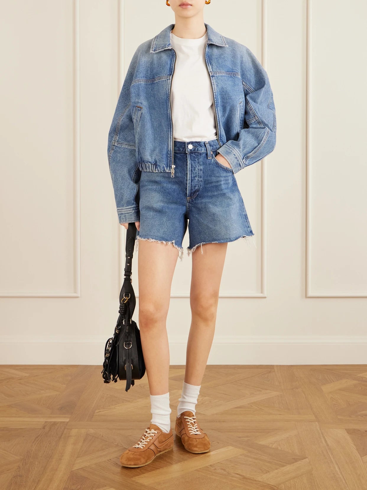 Image of a model wearing Shorts. Product name - Nye Frayed Denim Shorts in Dark denim colour by brand - AGOLDE