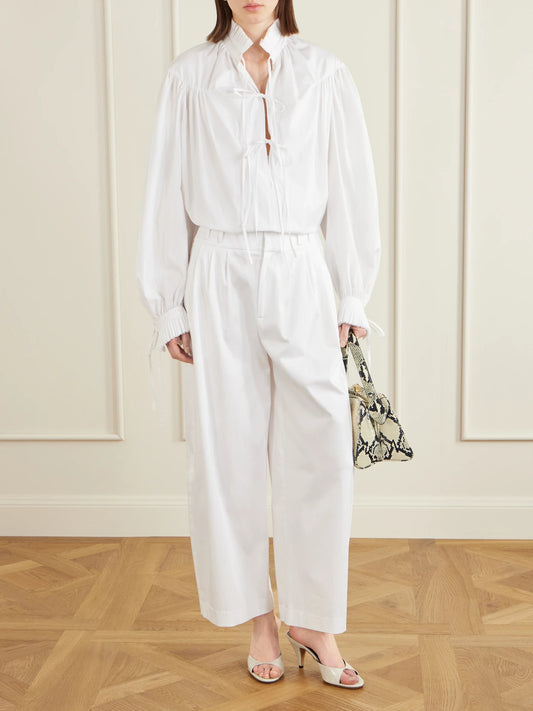 Image of a model wearing Pants. Product name - Wilson Pleated Cotton Wide-leg Pants in White colour by brand - Altuzarra