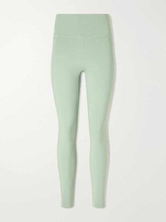 Image of a model wearing Pants. Product name - Universa 7/8 Stretch Leggings in Green colour by brand - Nike