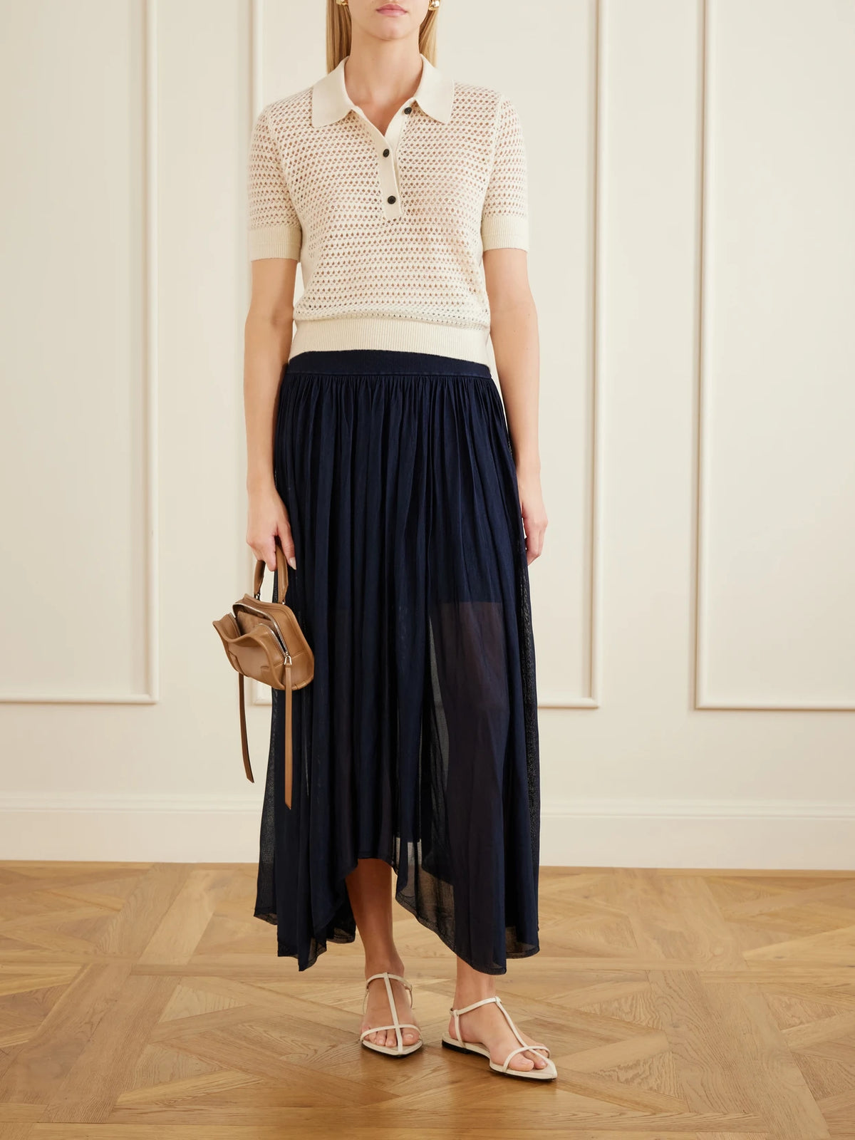 Image of a model wearing Skirts. Product name - Asymmetrical Plissé Midi Skirt in Navy colour by brand - Maria McManus
