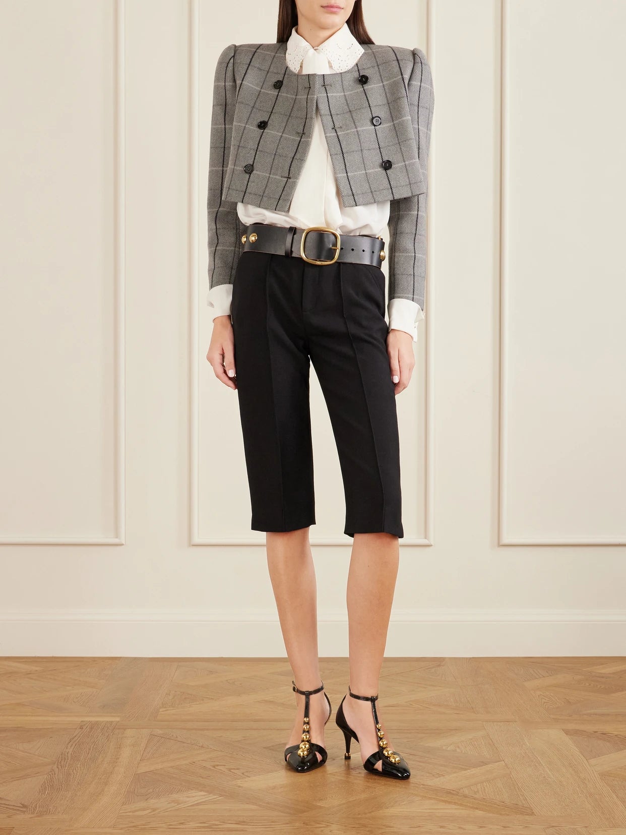 Image of a model wearing Pants. Product name - Buckle-embellished Wool-crepe Straight-leg Capri Pants in Black colour by brand - Chloé