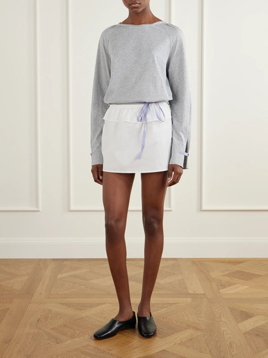 Image of a model wearing Skirts. Product name - Flounce Layer Organic Cotton-poplin Mini Skirt in White colour by brand - Deiji Studios