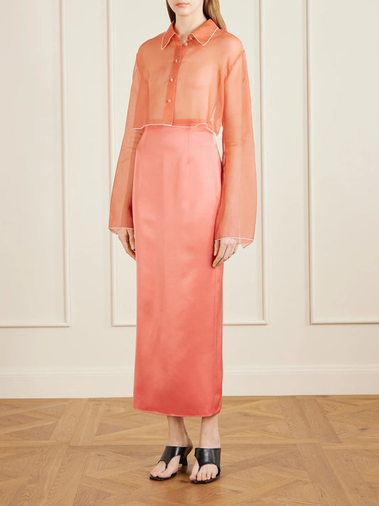 Image of a model wearing Skirts. Product name - Winton Satin Midi Skirt in Coral colour by brand - KHAITE