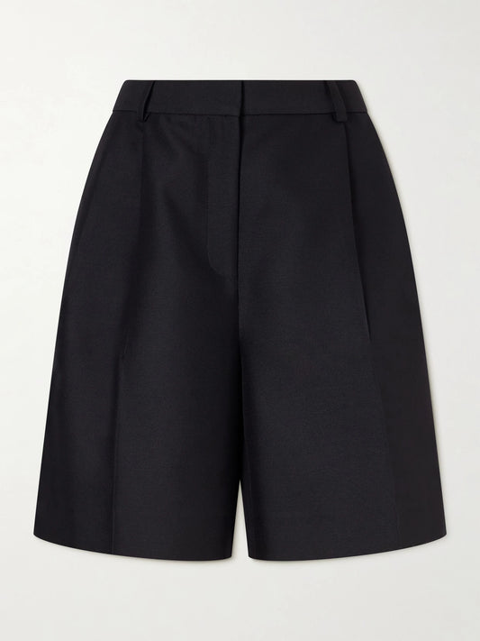 Image of a model wearing Shorts. Product name - Pleated Wool And Silk-blend Cady Shorts in Black colour by brand - KHAITE