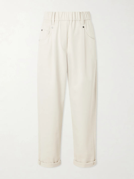 Image of a model wearing Pants. Product name - Tapered Cotton-blend Trousers in Sand colour by brand - Brunello Cucinelli