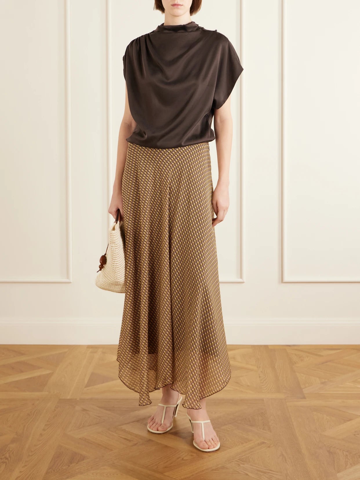 Image of a model wearing Skirts. Product name - Cooper Asymmetric Printed Chiffon Maxi Skirt in Tan colour by brand - SIR.