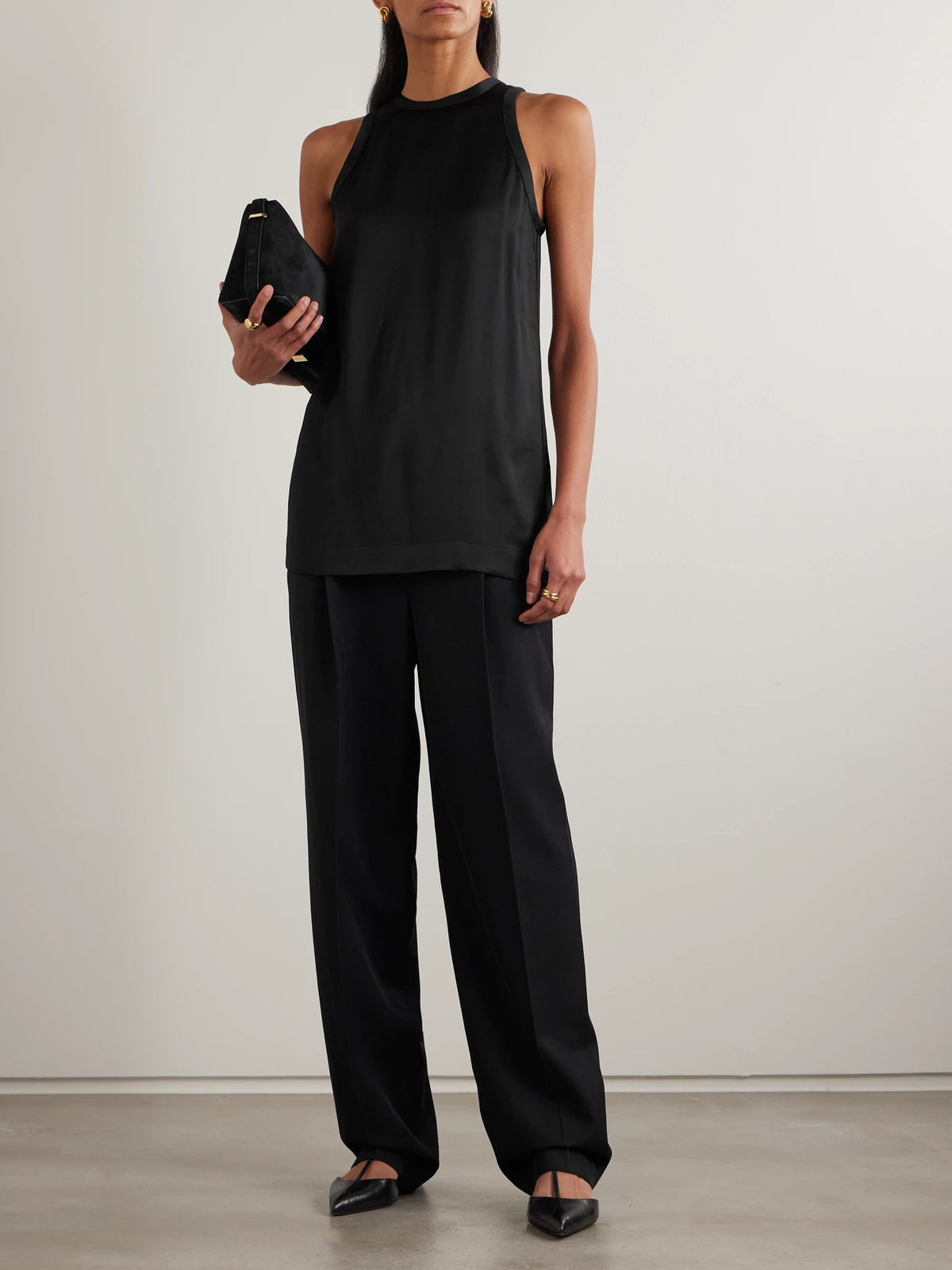 Image of a model wearing Pants. Product name - Pleated Twill Straight-leg Pants in Black colour by brand - TOTEME
