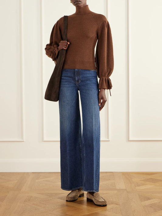 Image of a model wearing Outerwear. Product name - Camille Ruffled Ribbed-knit Merino Wool Turtleneck Sweater in Brown colour by brand - Ulla Johnson