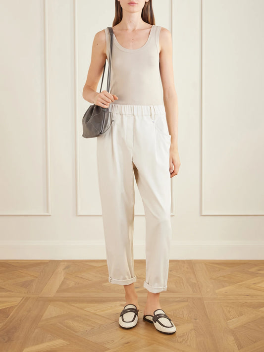 Image of a model wearing Pants. Product name - Tapered Cotton-blend Trousers in Sand colour by brand - Brunello Cucinelli