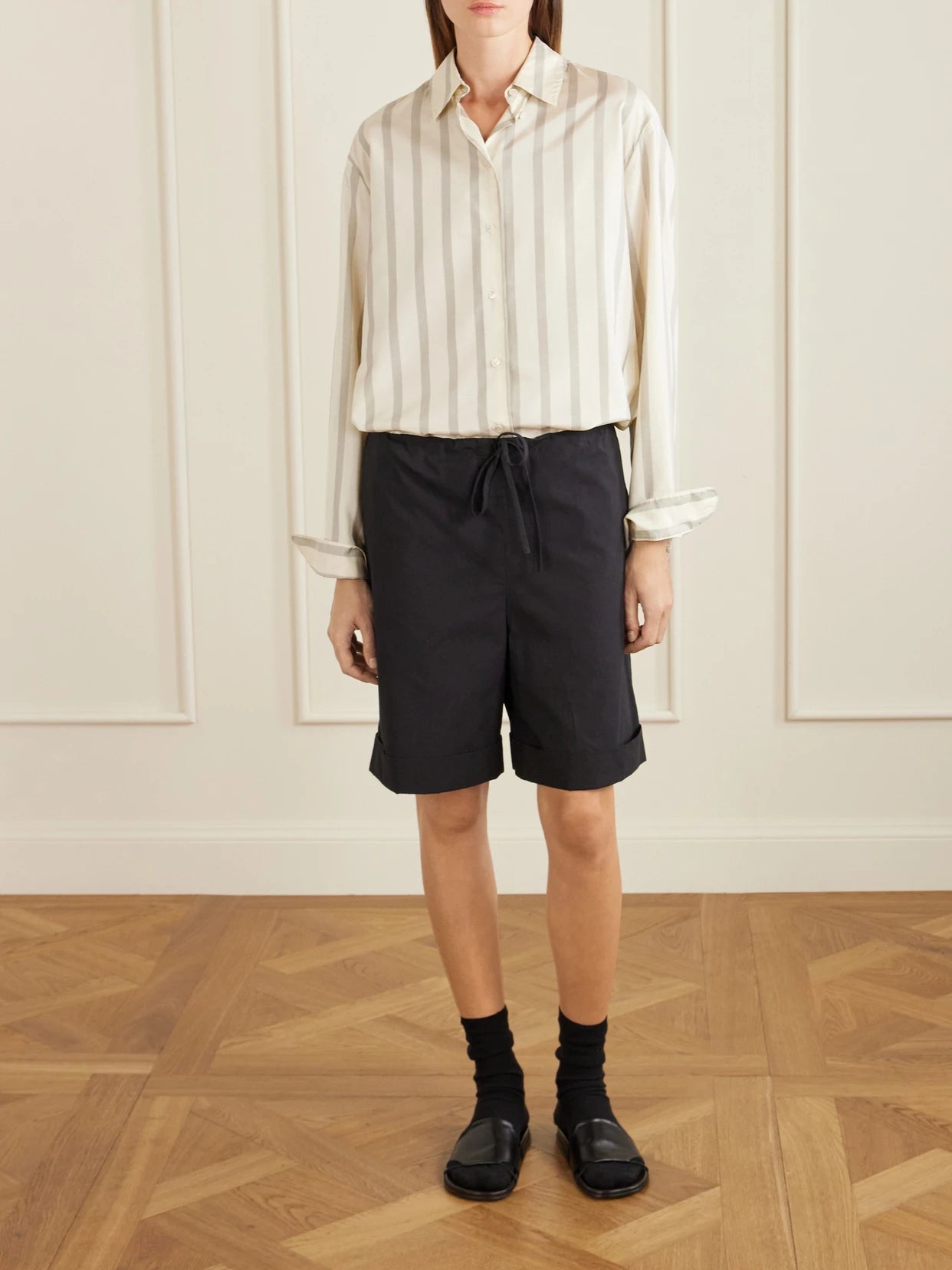 Image of a model wearing Shorts. Product name - Emiliano Cotton-poplin Shorts in Black colour by brand - The Row