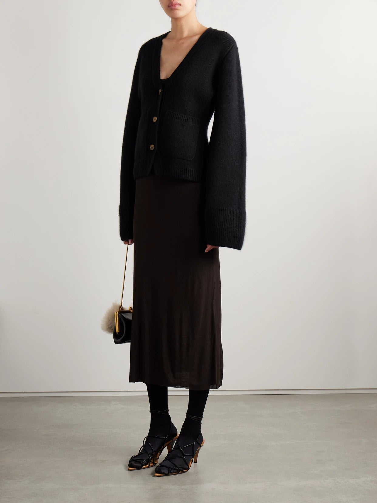 Image of a model wearing Outerwear. Product name - Scarlet Cashmere-blend Cardigan in Black colour by brand - KHAITE