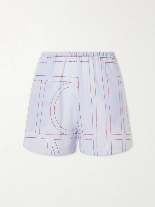 Image of a model wearing Shorts. Product name - Monogram Cotton-blend Shorts in Light blue colour by brand - TOTEME