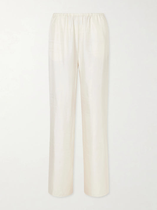 Image of a model wearing Pants. Product name - Monogram Silk Wide-leg Pyjama Pants in Cream colour by brand - TOTEME