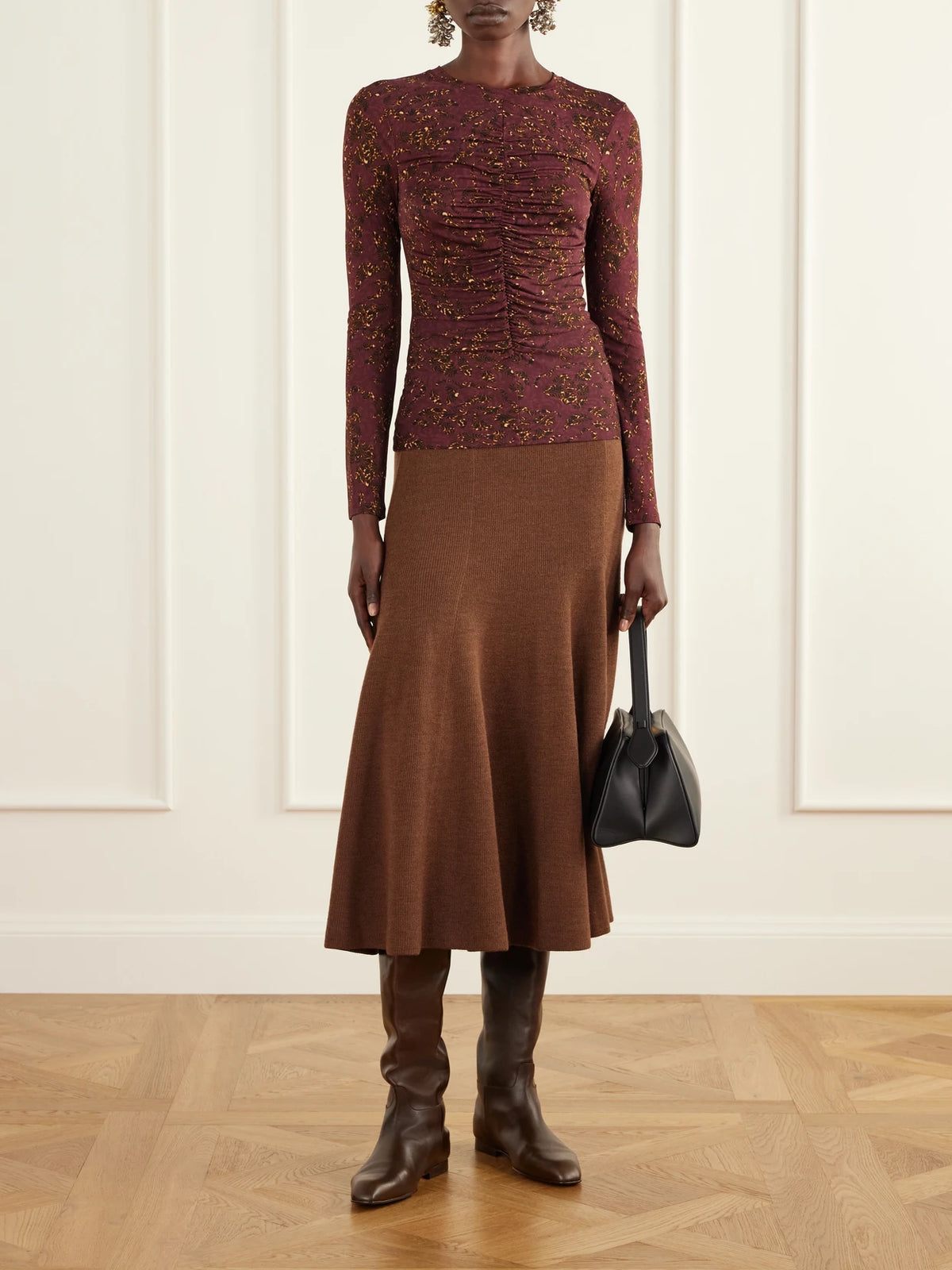 Image of a model wearing Skirts. Product name - Azaria Merino Wool Midi Skirt in Brown colour by brand - Ulla Johnson